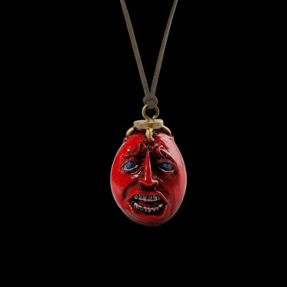 Red face pendant on a black background