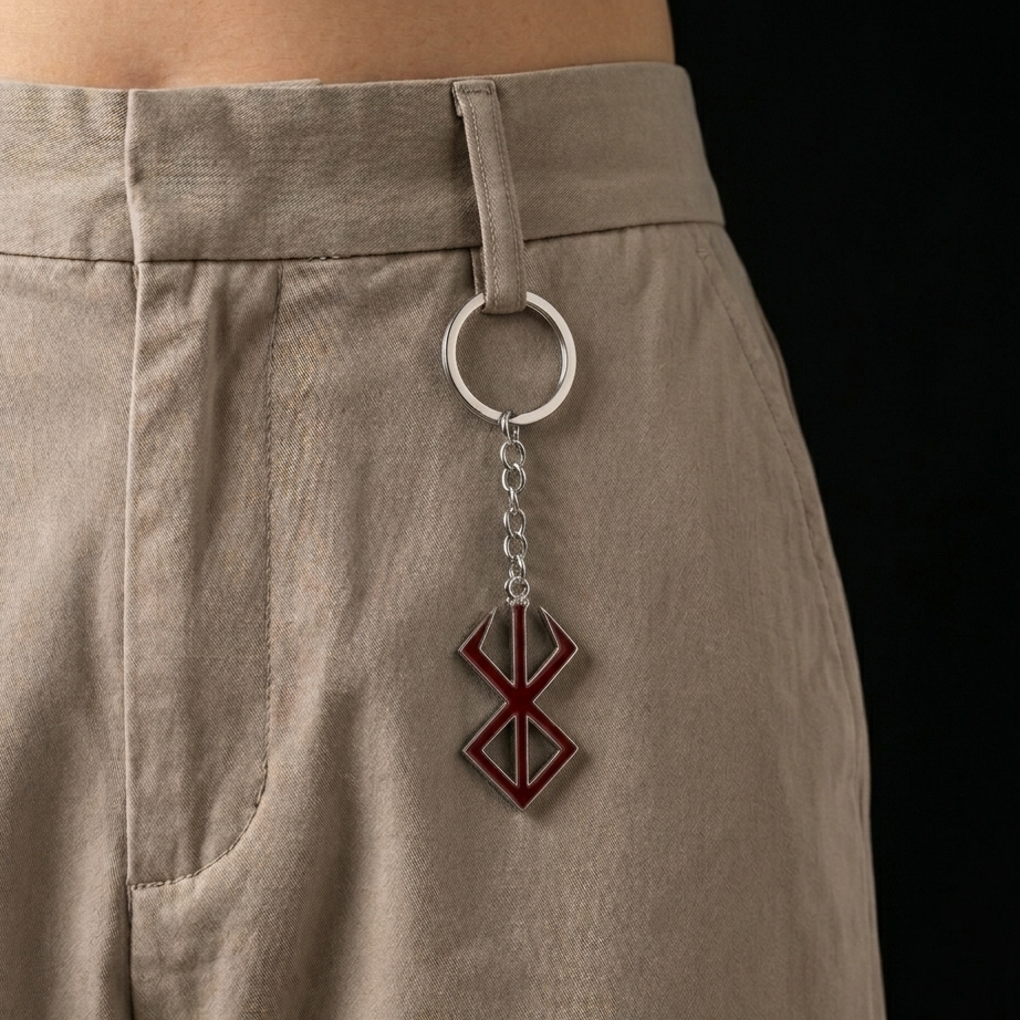 Keychain with a geometric design attached to beige pants on a black background