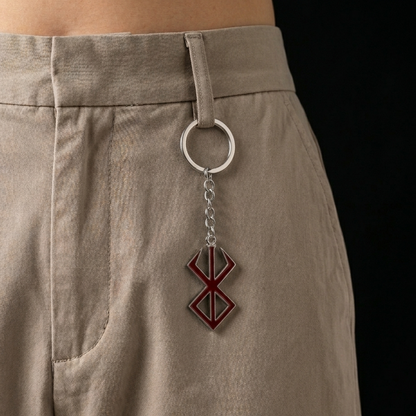 Keychain with a geometric design attached to beige pants on a black background