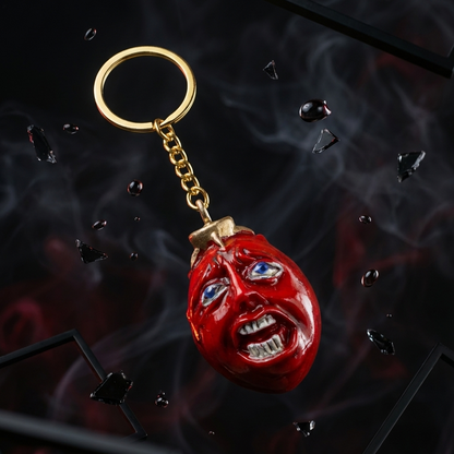 Red boxing glove keychain with gold chain on a dark background