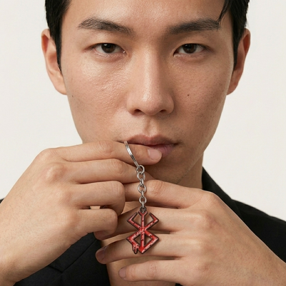 Man holding a red and silver pendant against a neutral background