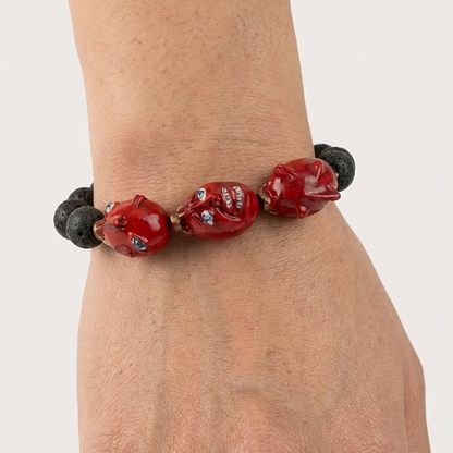 Bracelet with red and black beads on a wrist against a white background