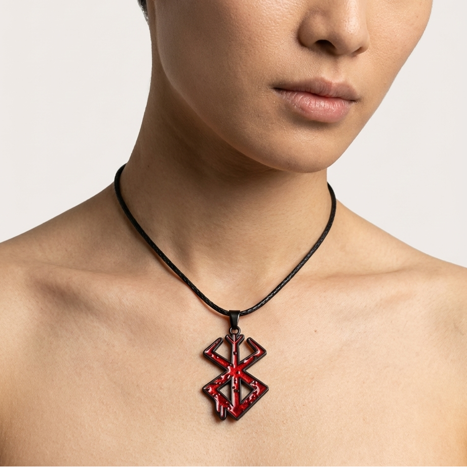 Person wearing a necklace with a red pendant on a plain background