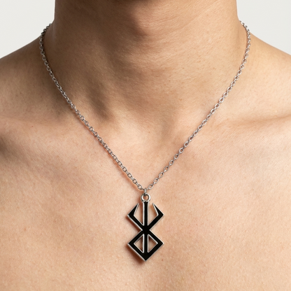 Necklace with a black pendant on a person's neck against a neutral background